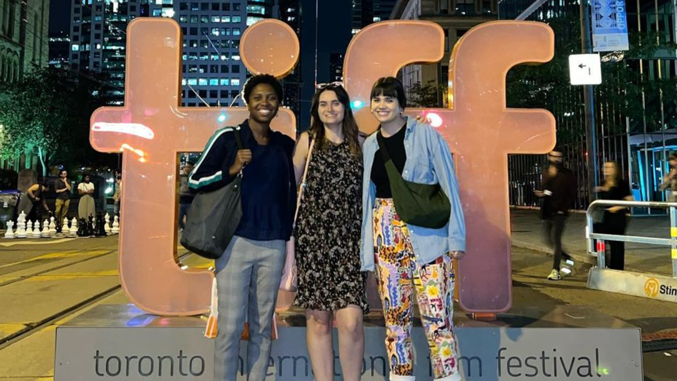 Goldring arts journalism student stand in front of Toronto Film Festival sign