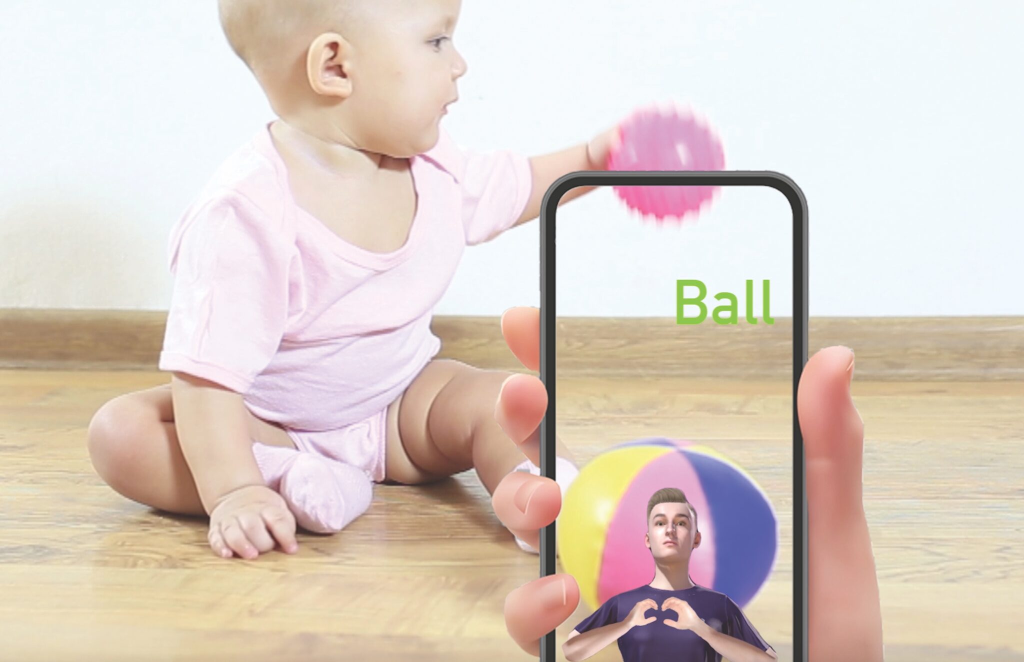 A baby plays with a ball while a hand holds a phone in the foreground.