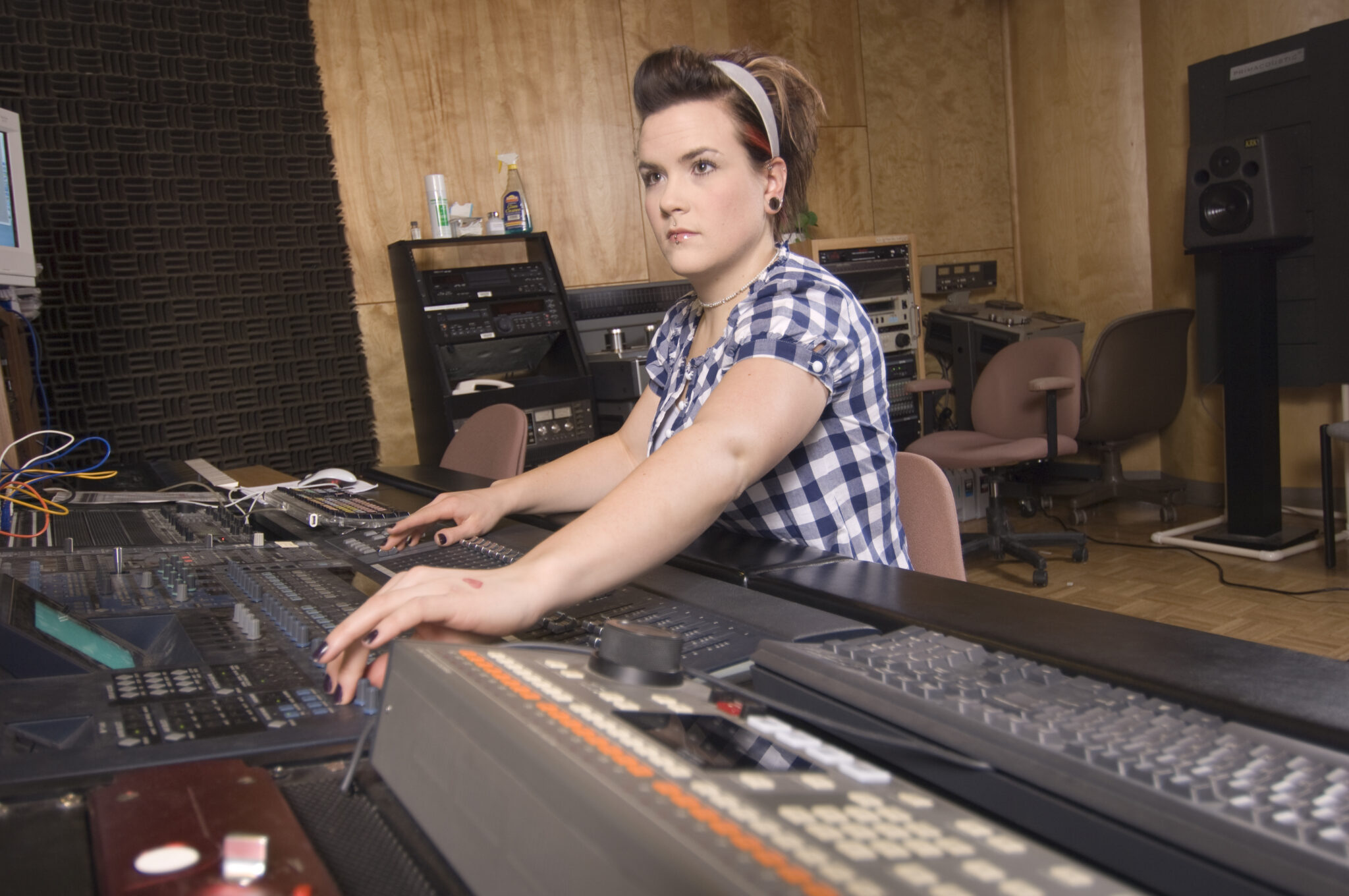 Female student works audio board during a recording session