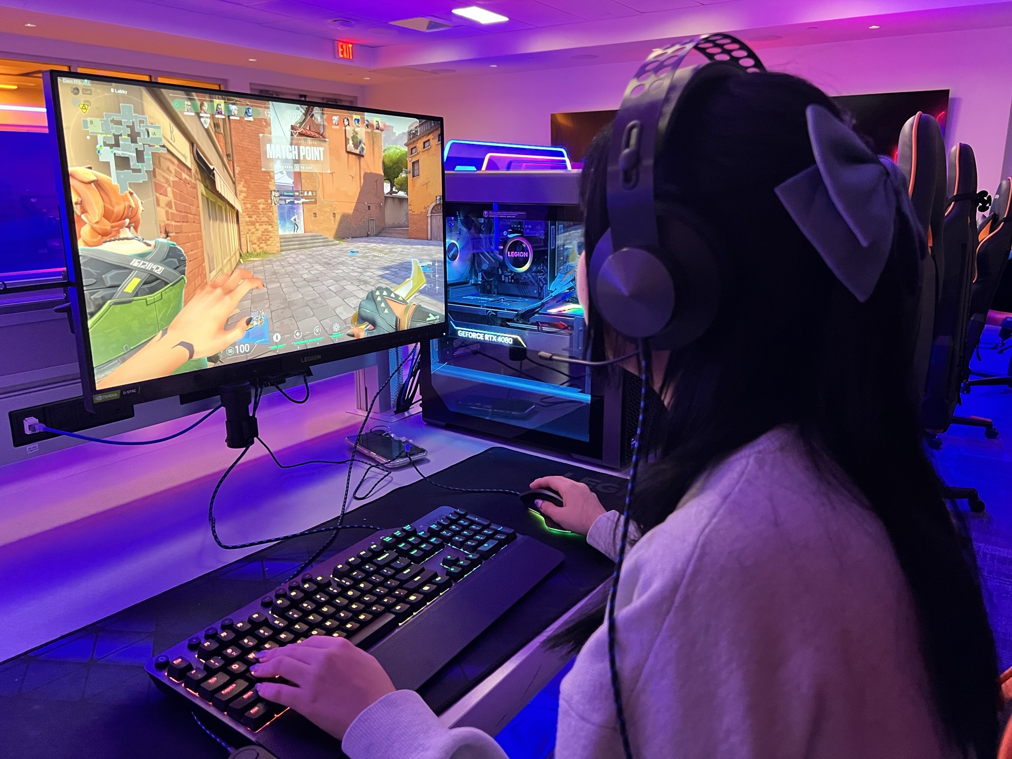 Female student plays video game on esports gaming station