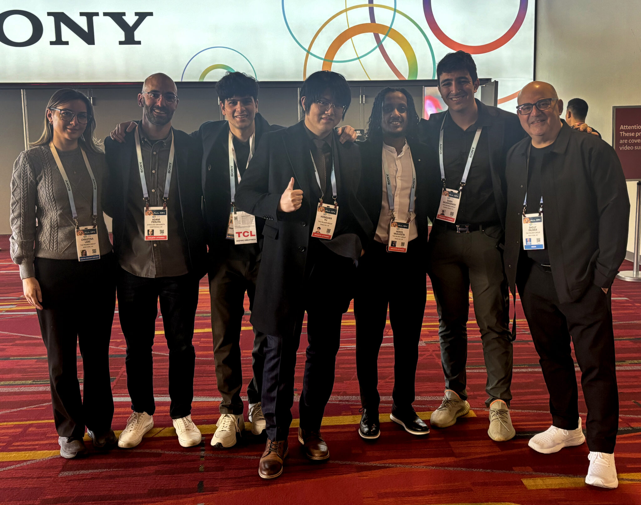 seven people pose together on the floor of the CES tech event