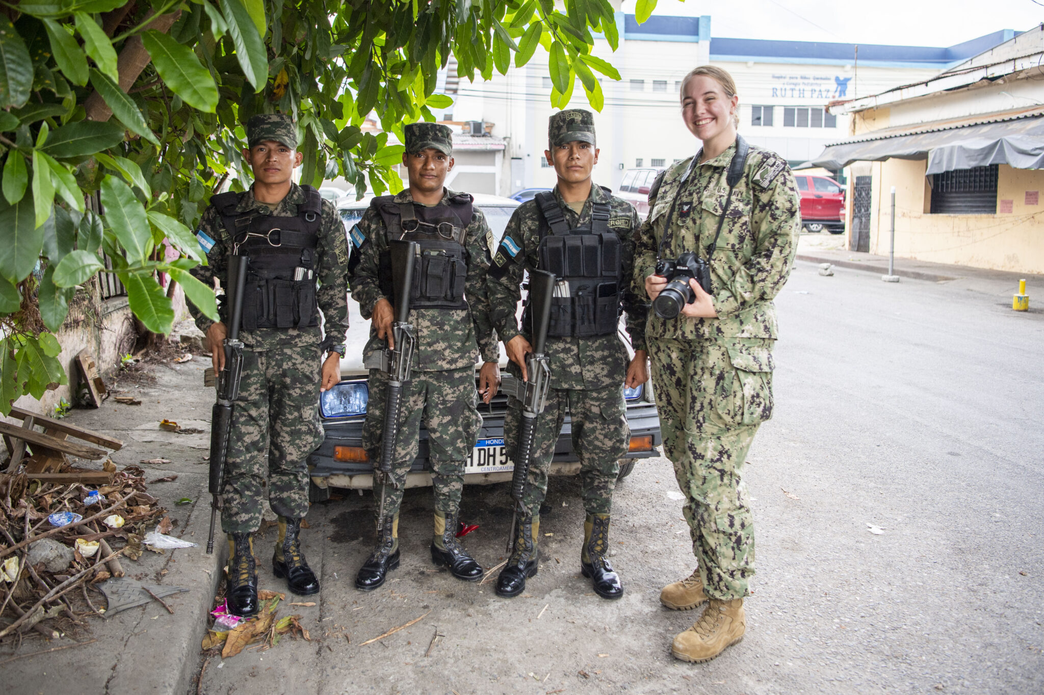military personnel pose for a photograph in the middle of a street