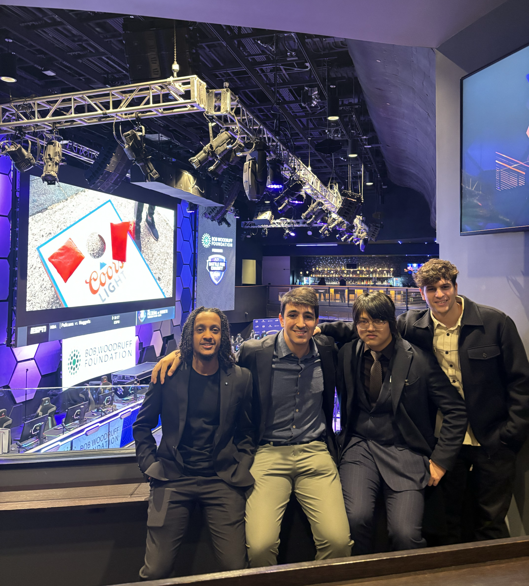 4 people pose together in an esports arena
