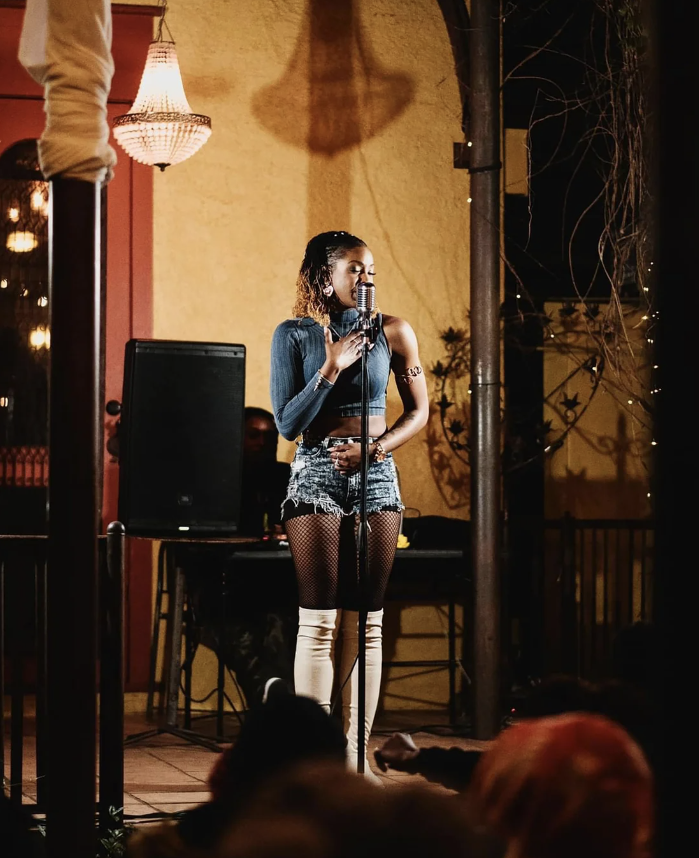 a woman stands on a stage and speaks into a microphone 