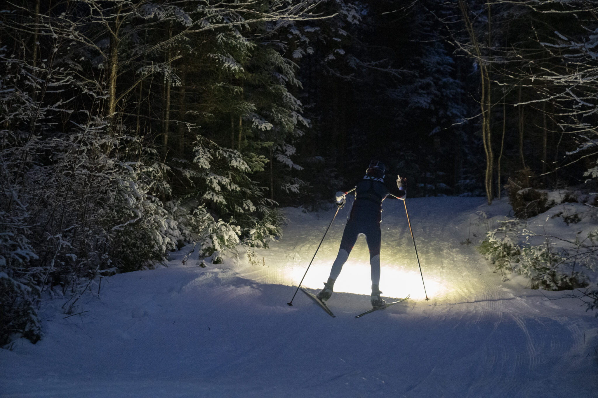 a cross country skier skis at night