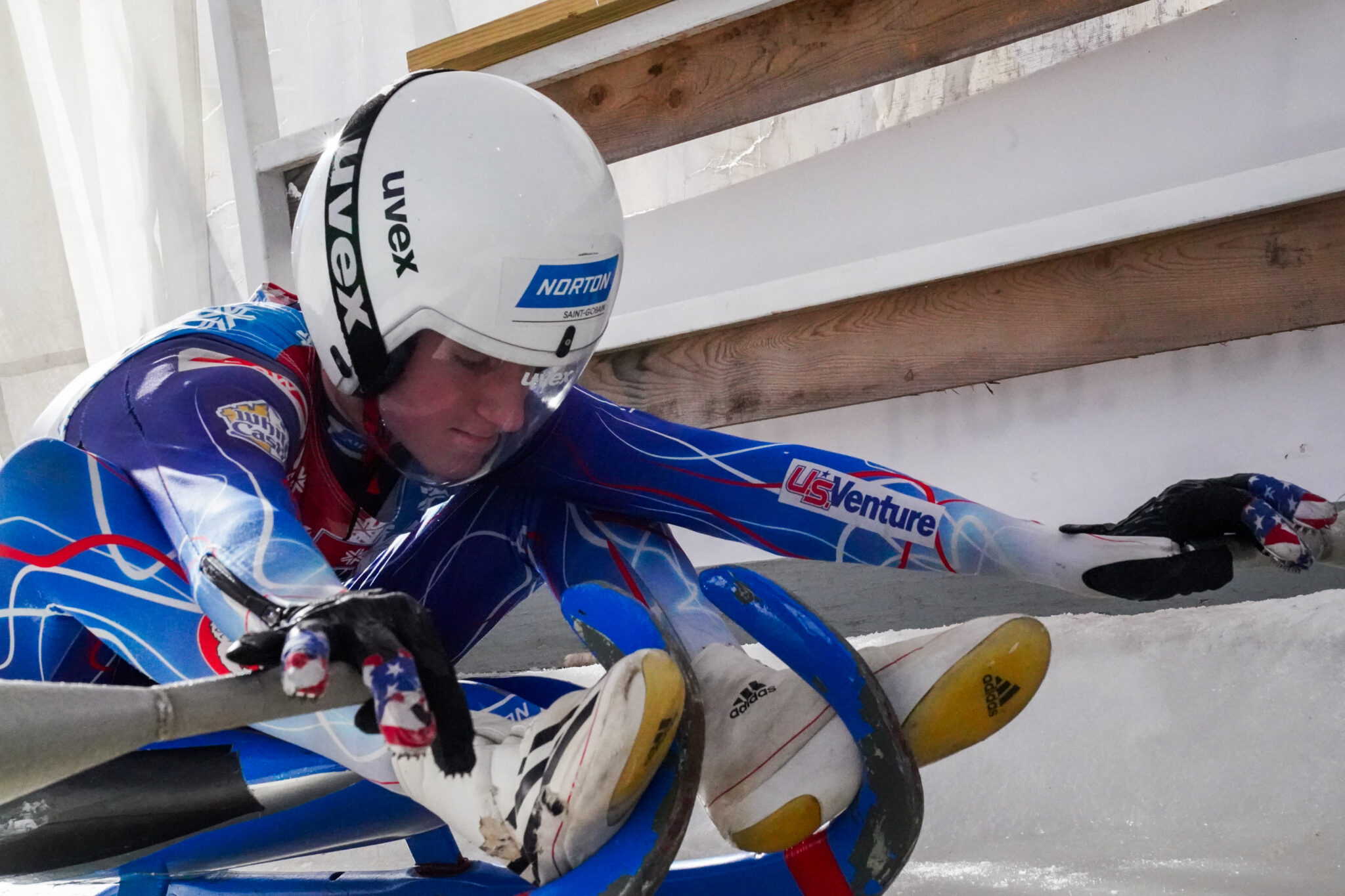 A luge racer prepares to head down a track