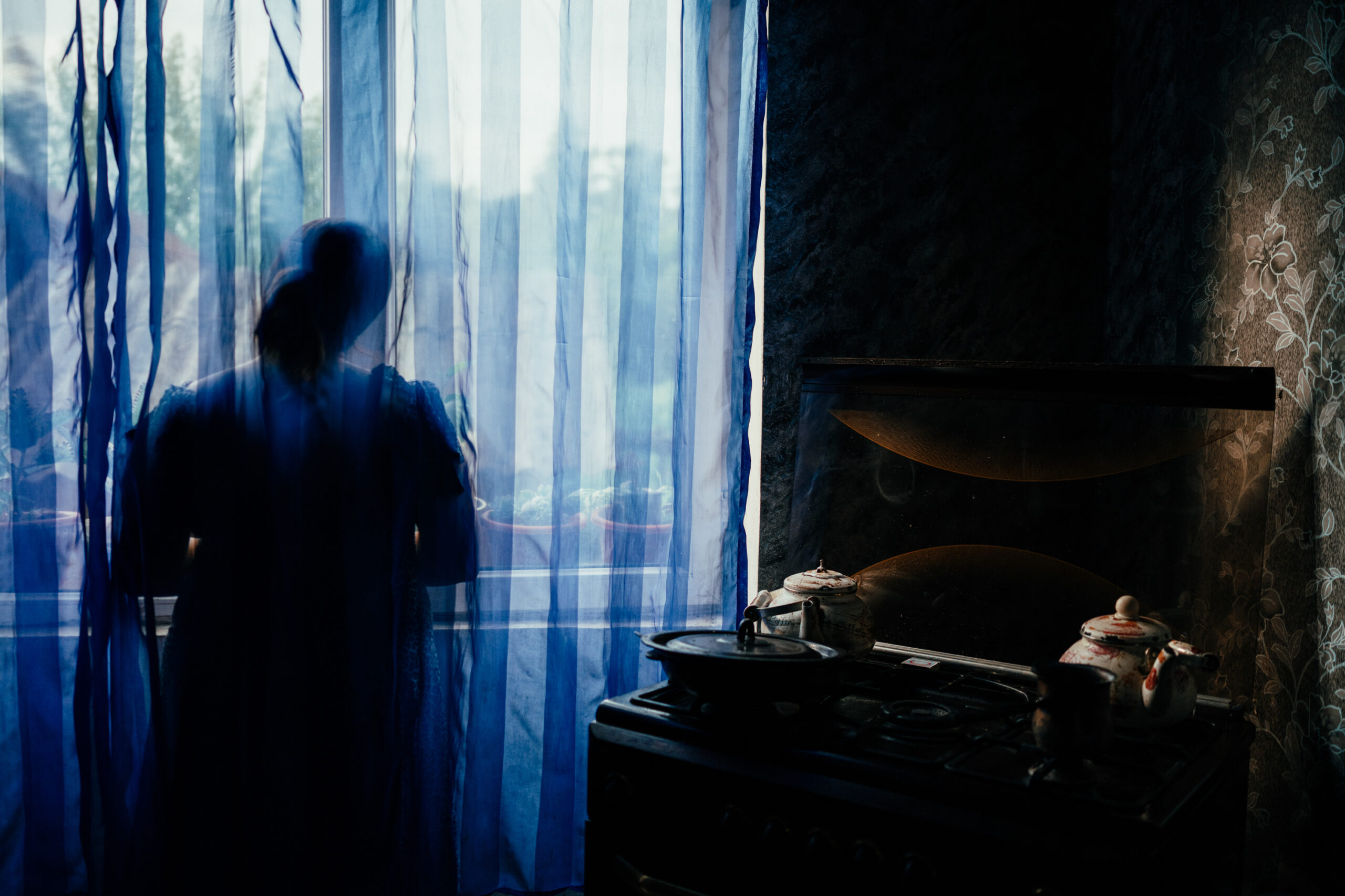 the silhouette of a person behind a curtain in a room