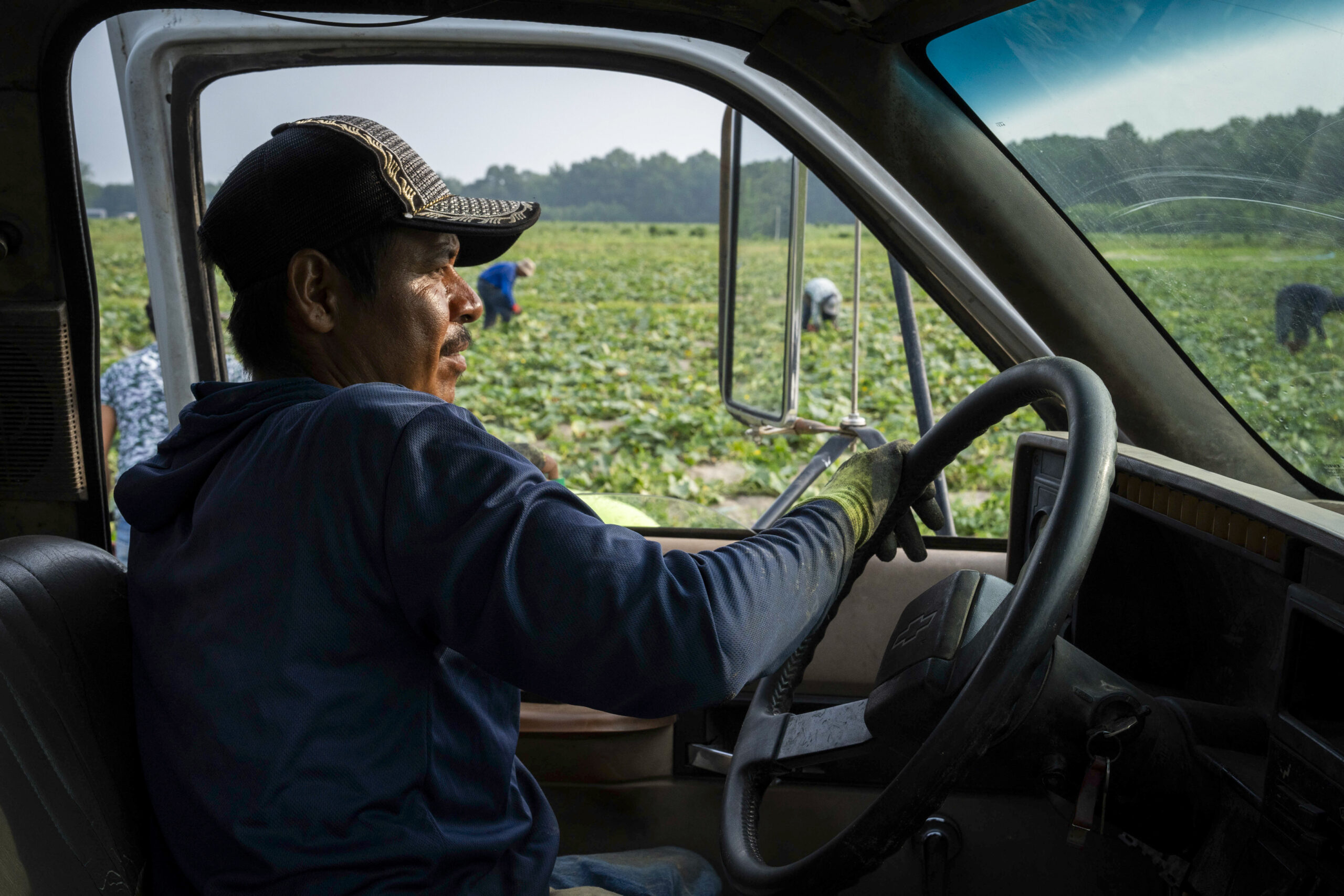 a person sits in a truck on a field
