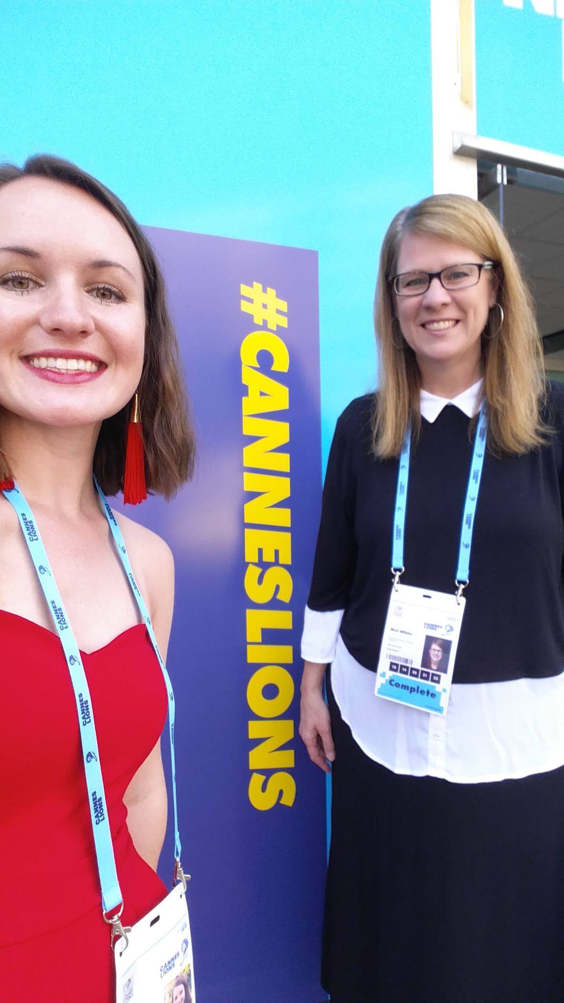 Two people take a selfie in front of a sign that says #CannesLions