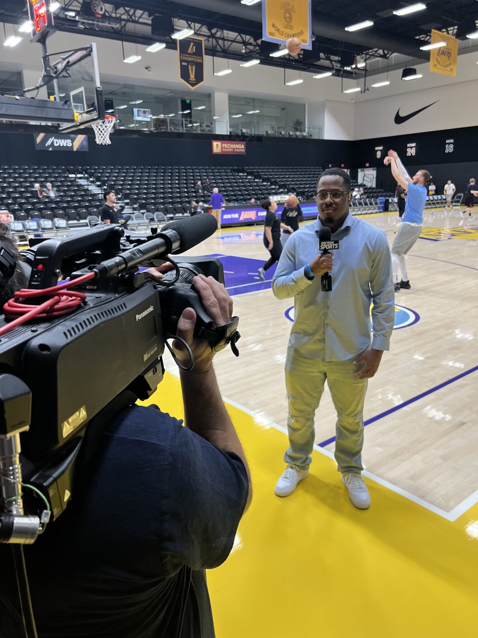 a person gives a sports broadcast standing on a basketball court