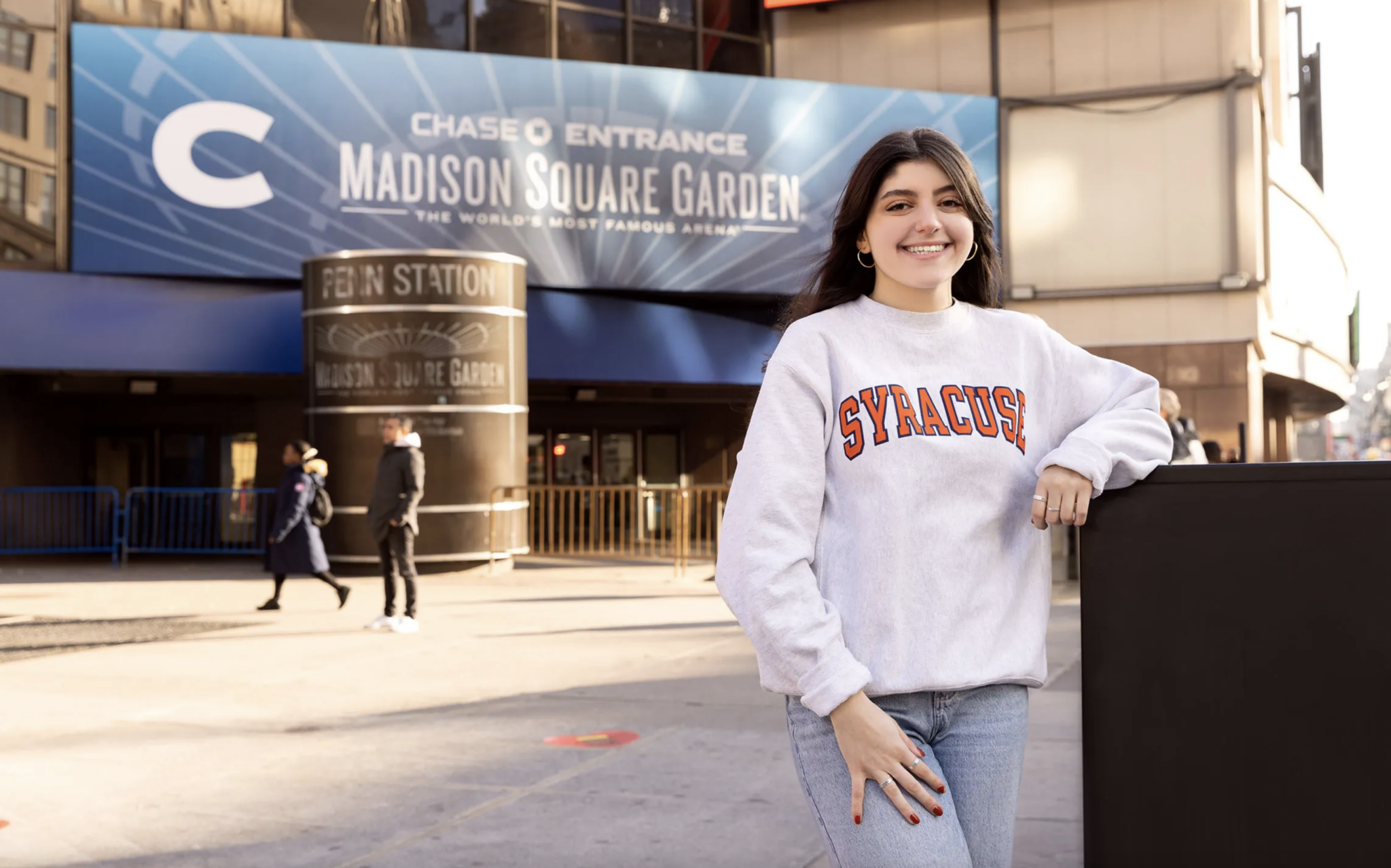 a person stands in front of Madison Square Garden in New York City
