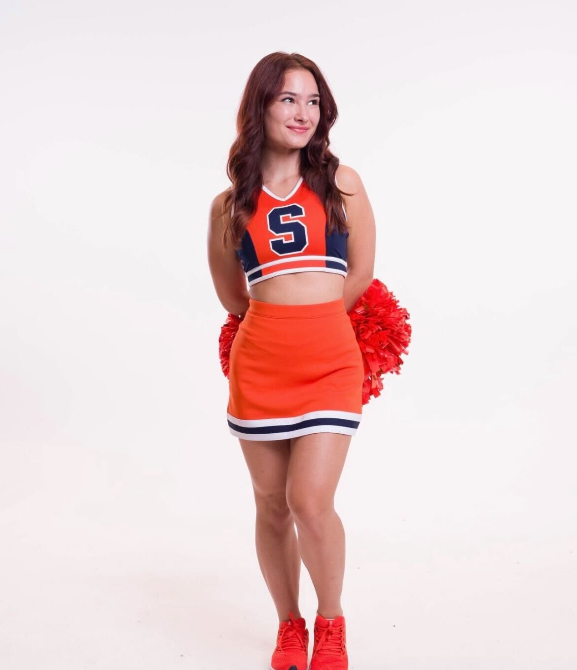 a person poses in a cheerleading uniform