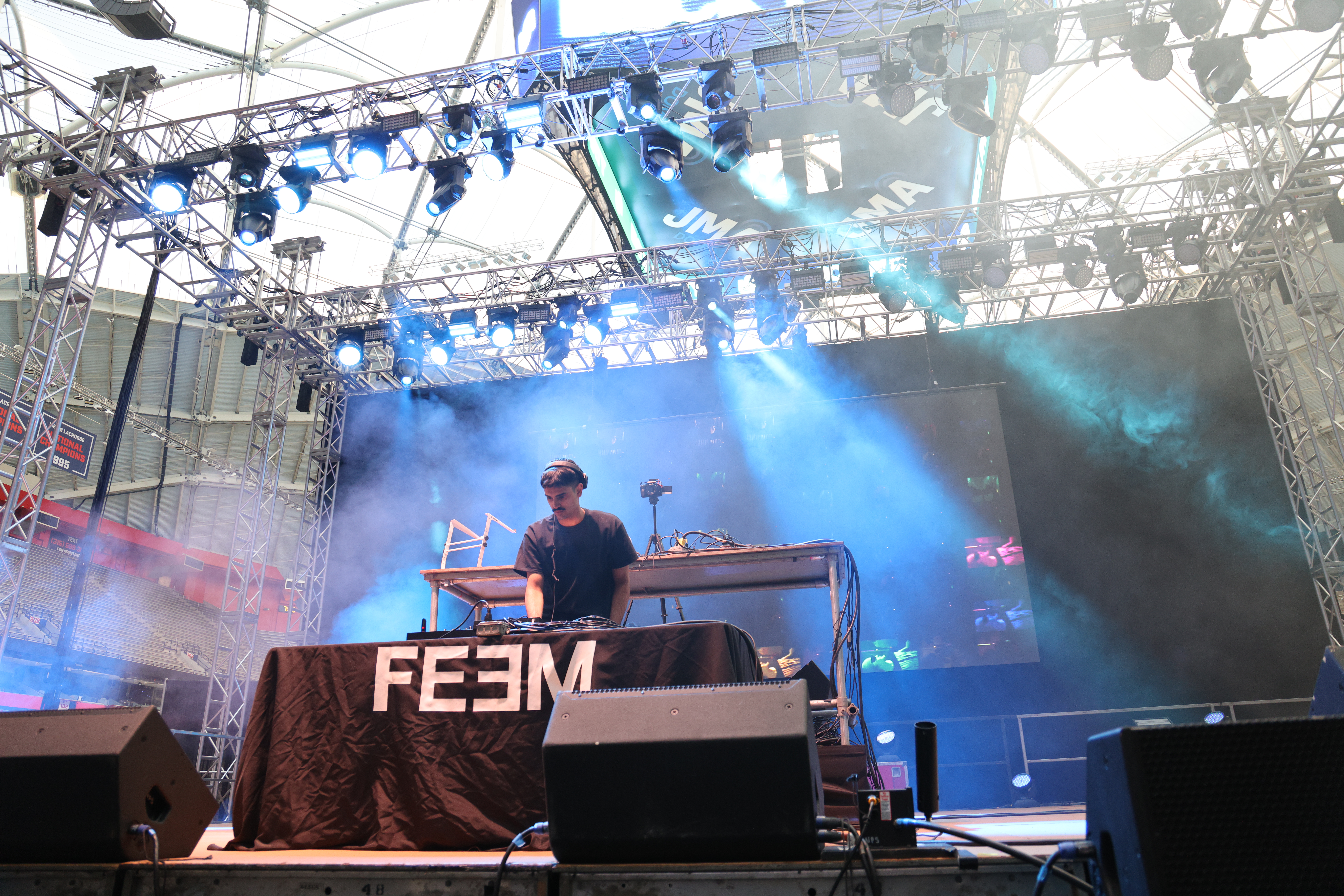 a DJ performs on a stage at a concert