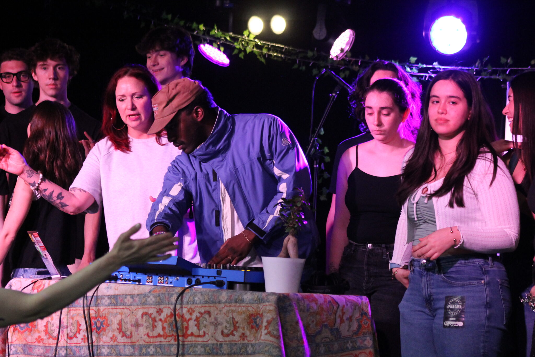 a group of people stand behind a DJ table at a concert
