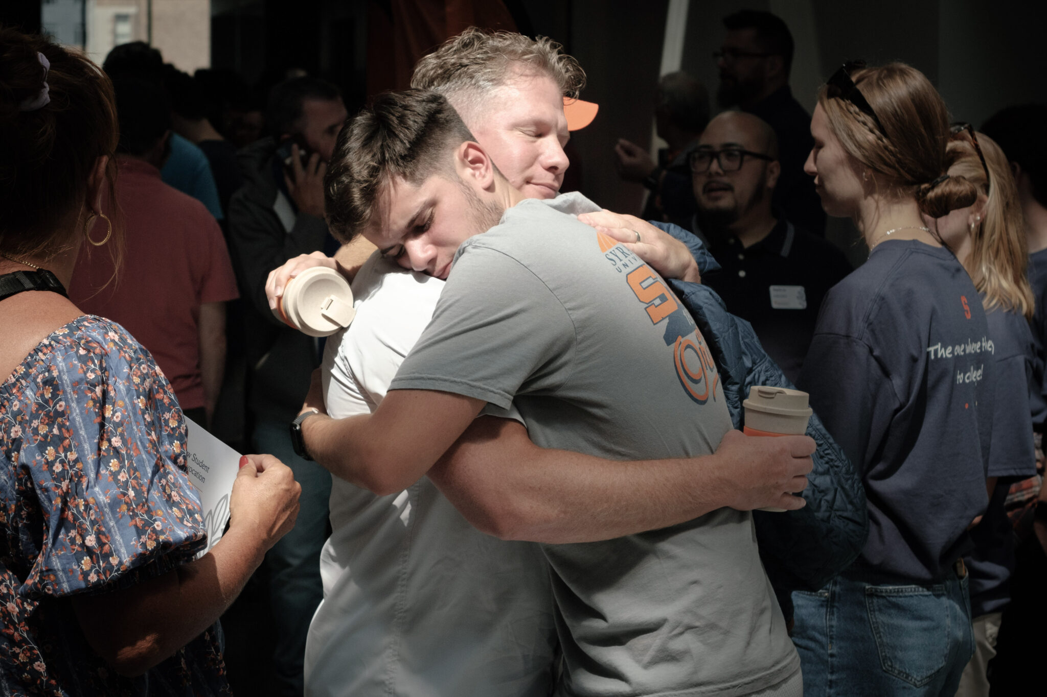 two people hug in a crowded room