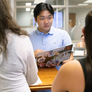 male student holds laptop in advanced data journalism class