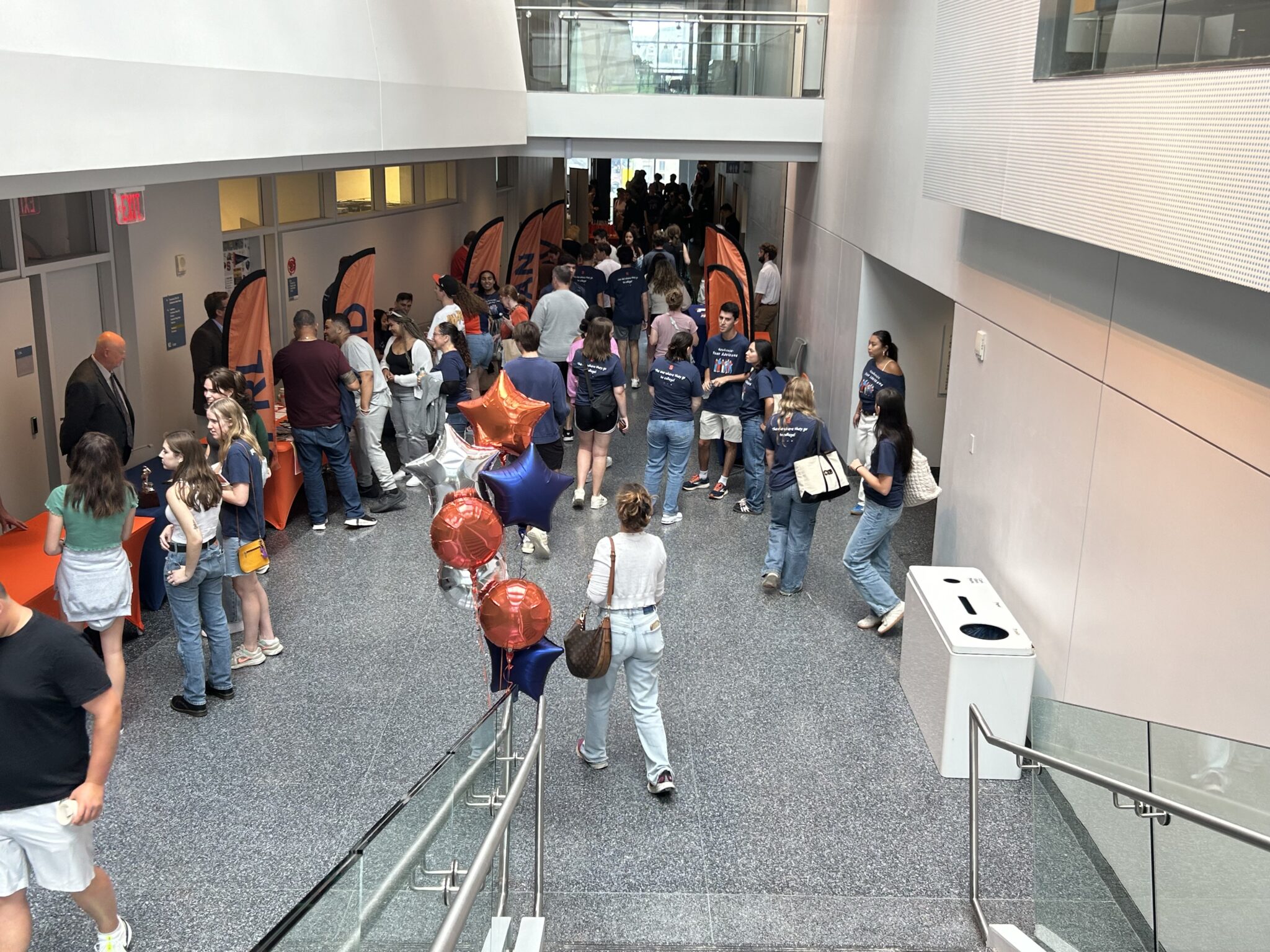 a large group of people mingle in a large hallway