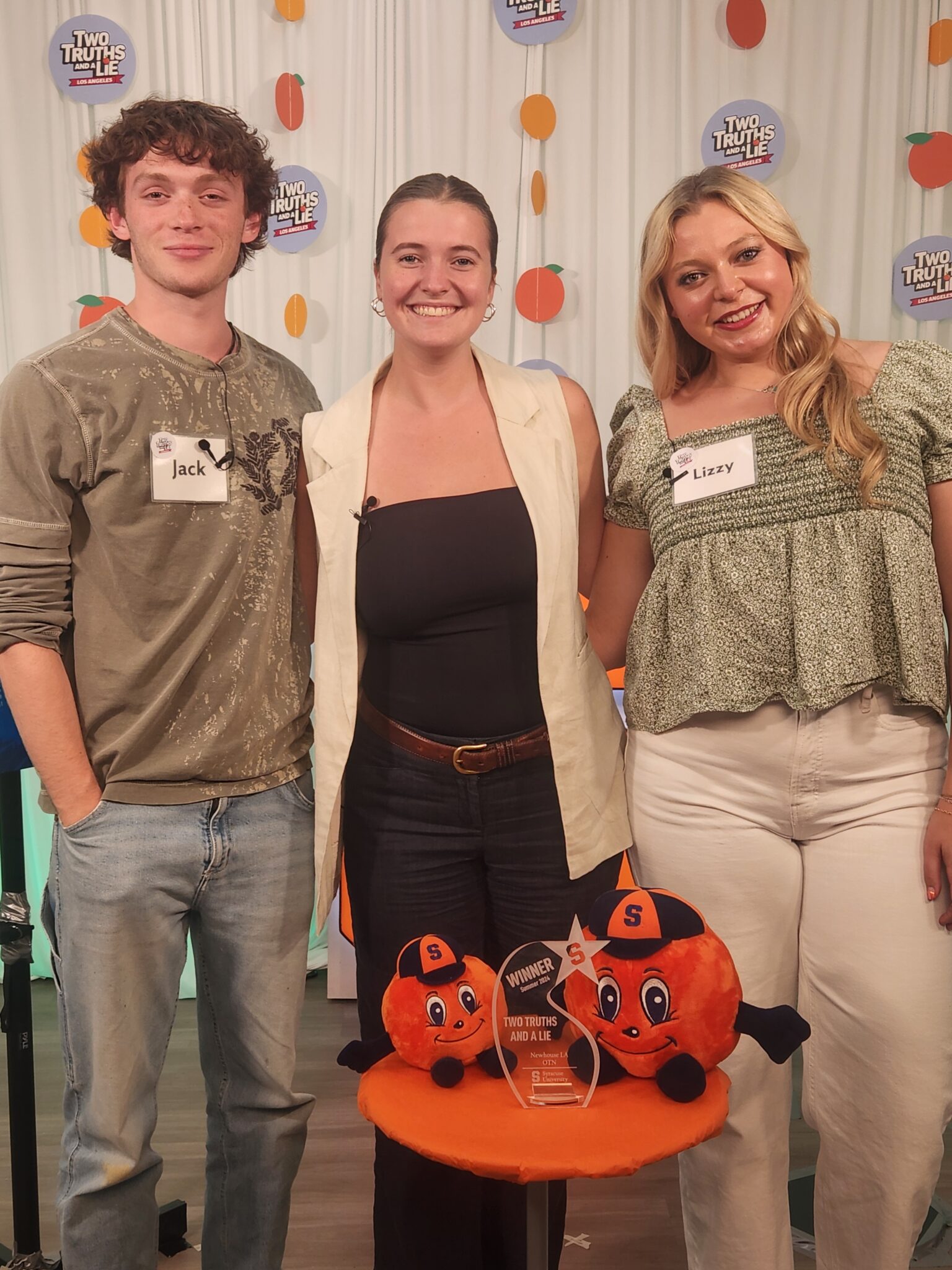 three people smile and pose for a photograph