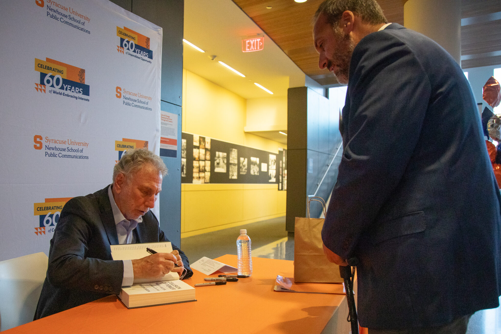 a person sits at a table and signs a book