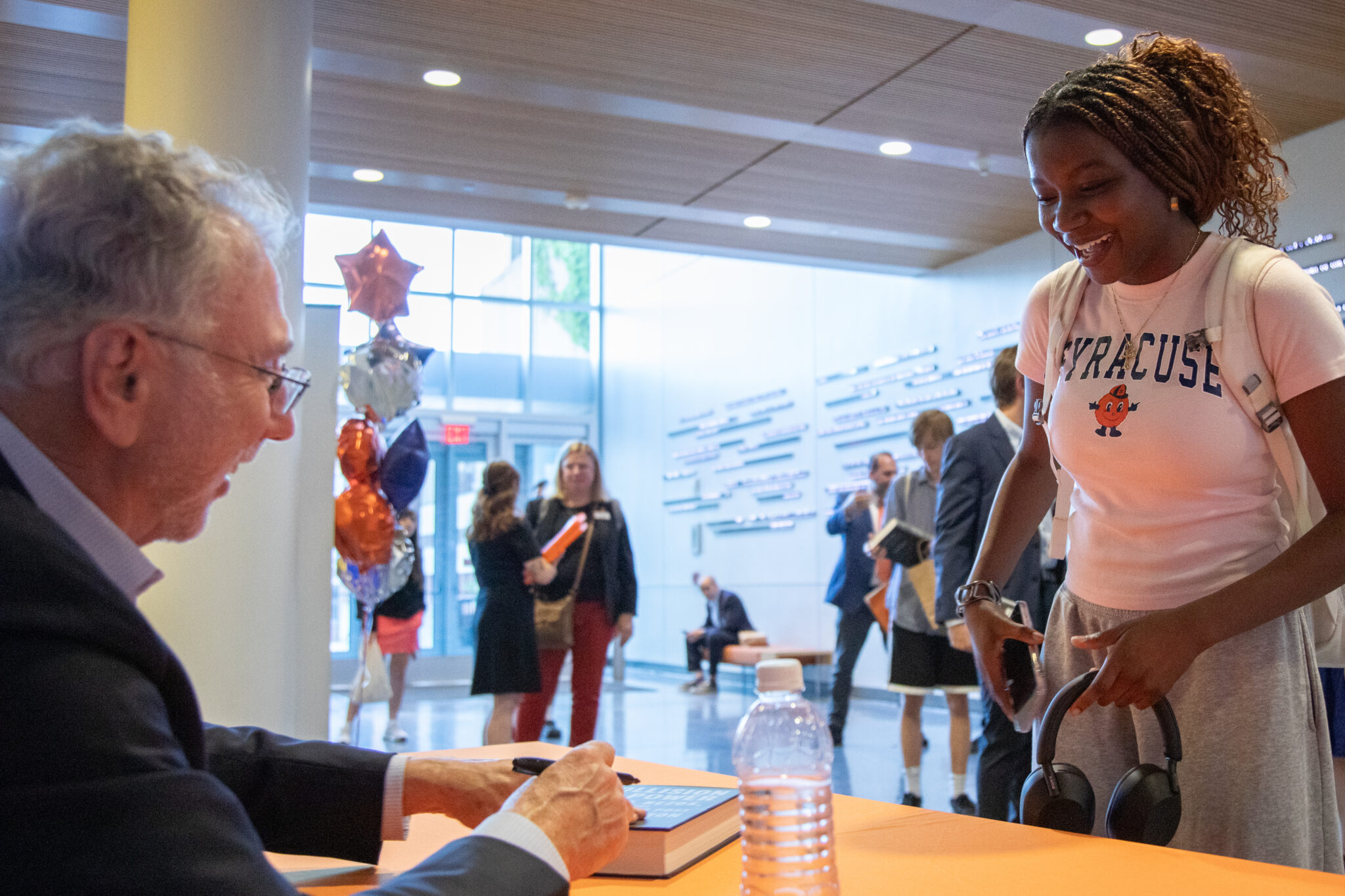 a person sits at a table and signs a book