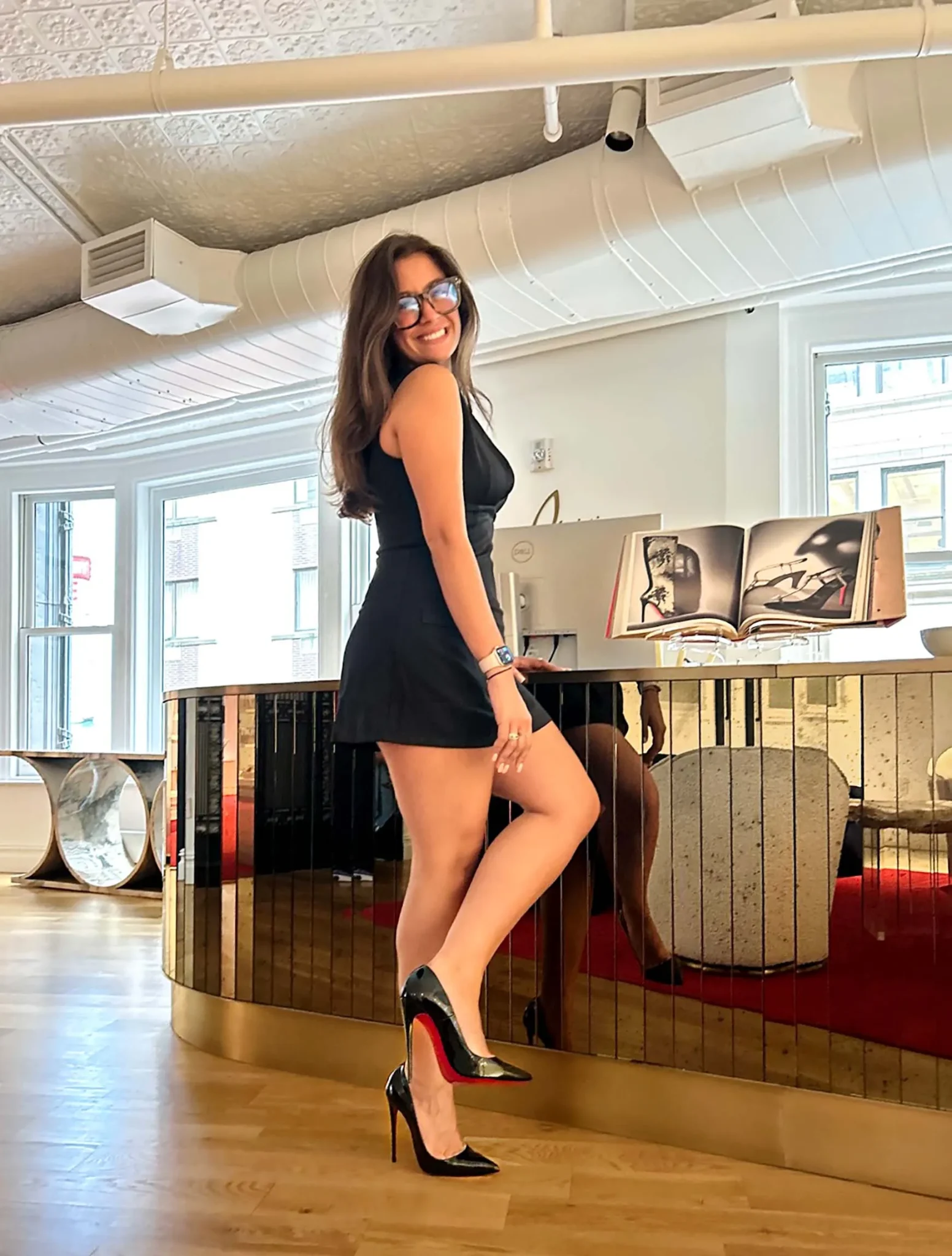 a person smiles and poses in high heels standing in a store