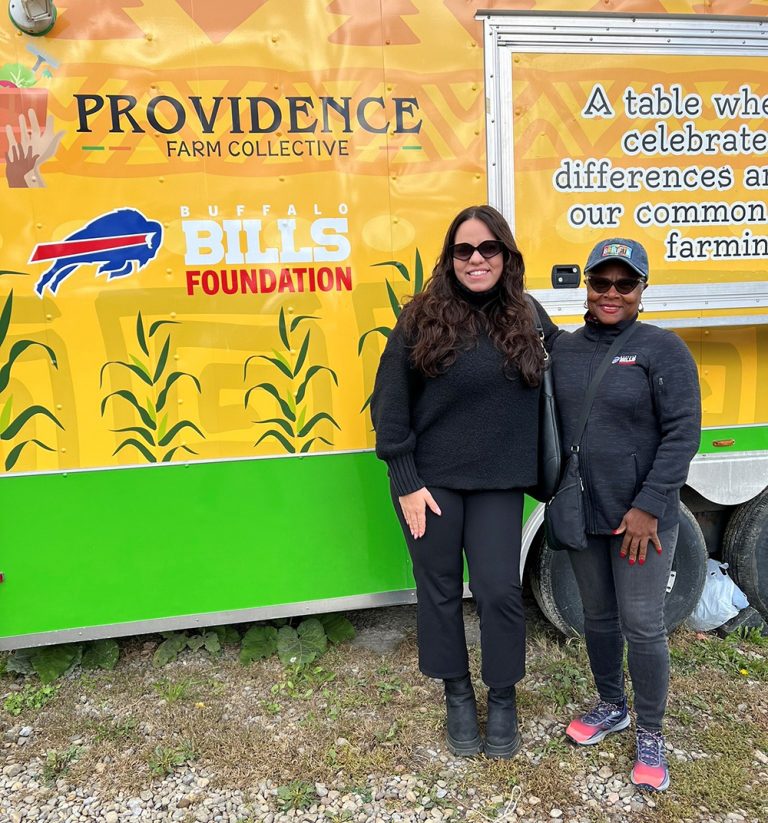 two people stand together in front of a food truck