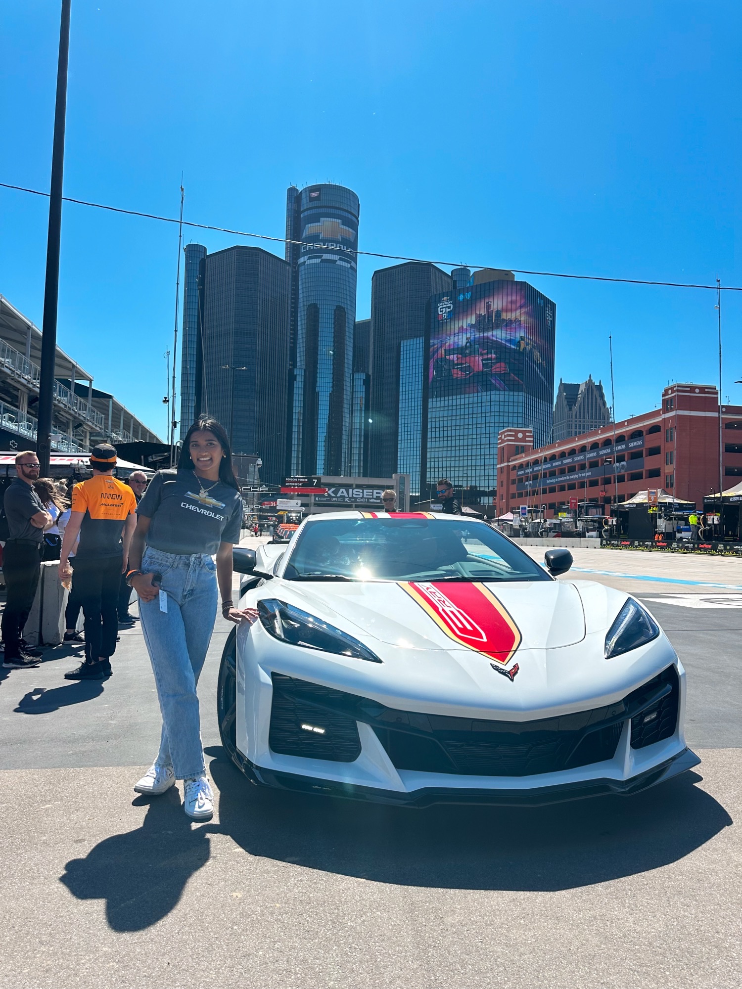 a person stands next to a Chevrolet corvette 