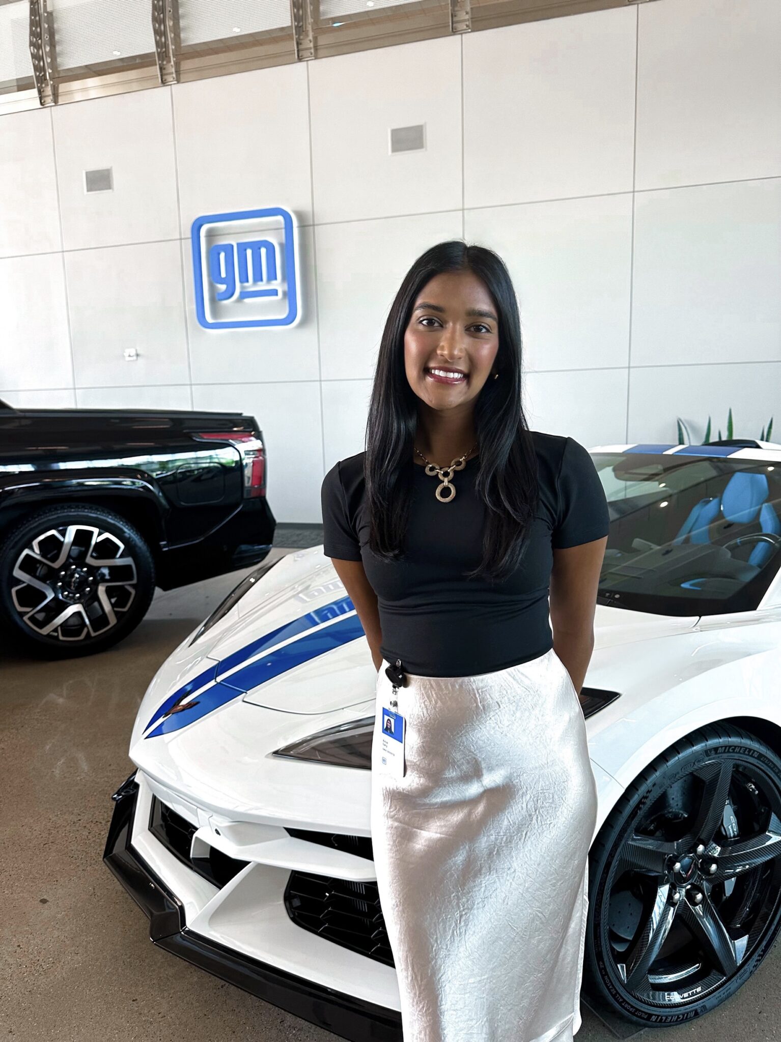 a person stands in front of a car and poses for a photograph