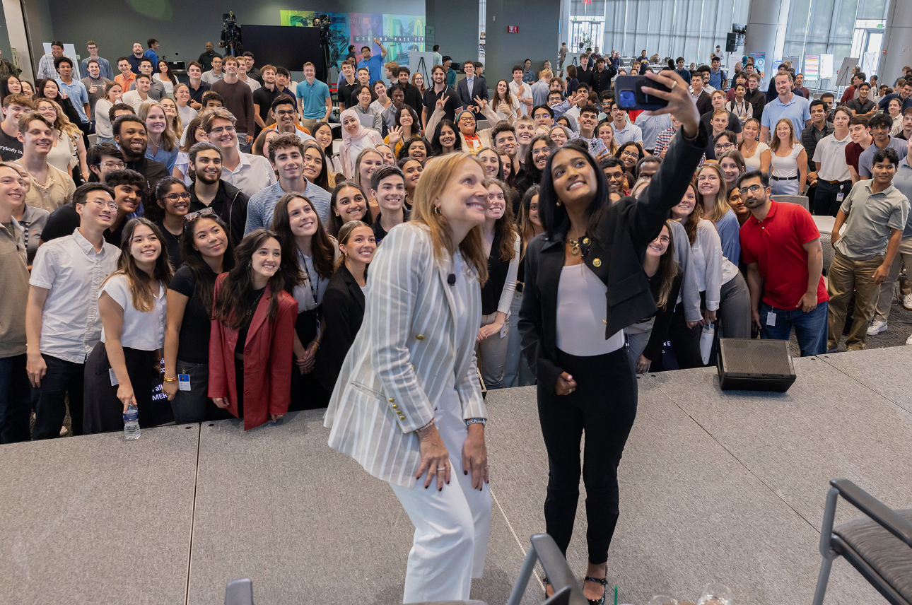 two people take a selfie while standing on a stage