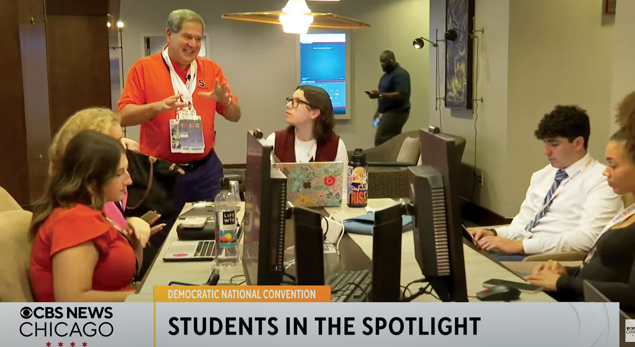 A screenshot shows a CBS News Chicago report featuring Professor Joel Kaplan (standing) and Newhouse students at the DNC.