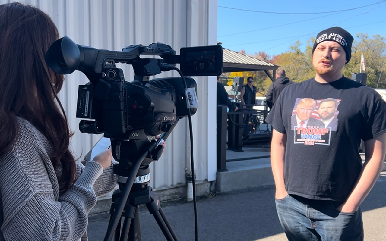 A Newhouse School broadcast journalism student interviews a man during a reporting trip to Pennsylvania for Advance Local