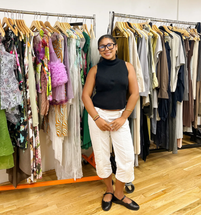 Shayla Ismael stands in front of a rack of clothing