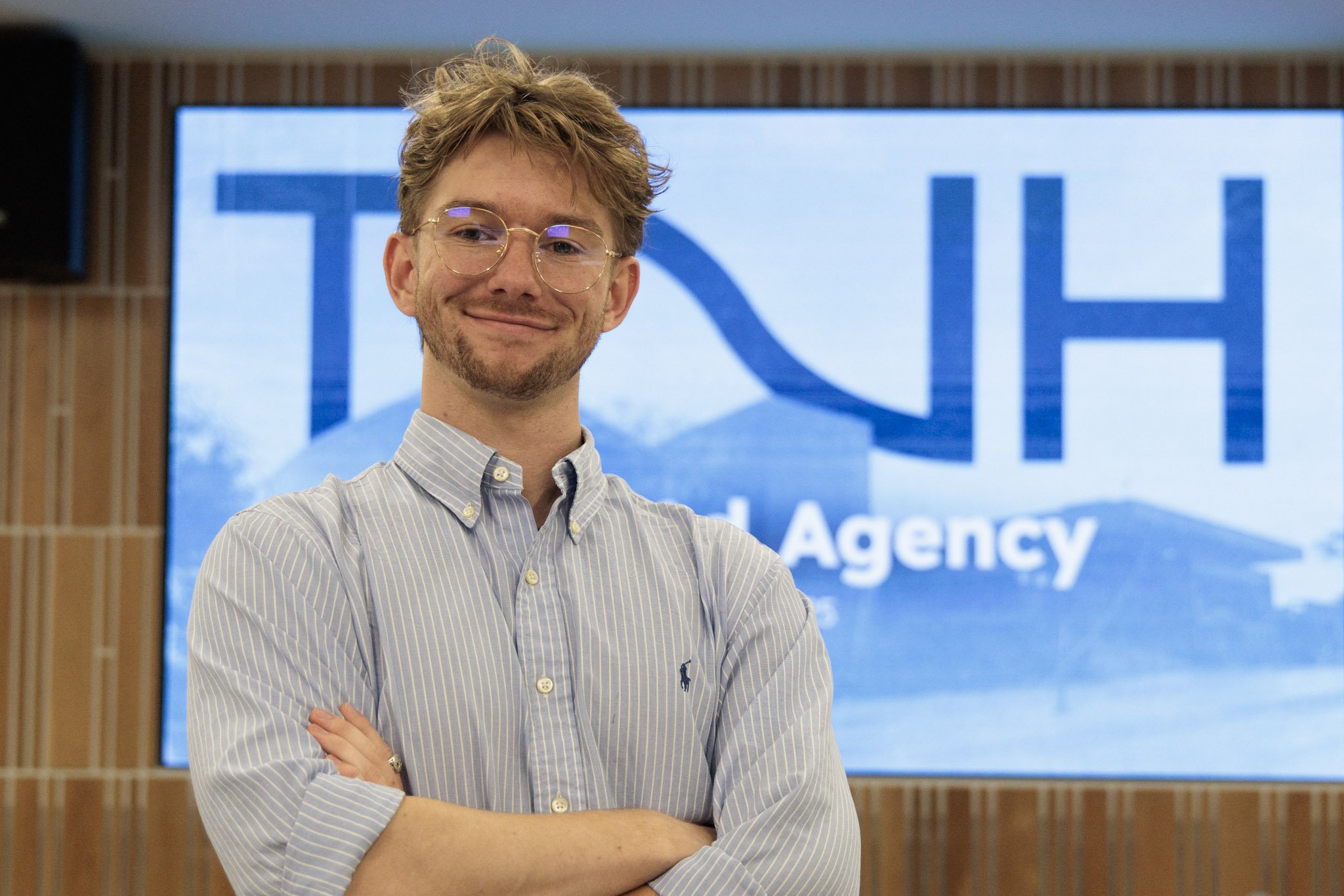 Cole Meredith poses in front of the TNH logo